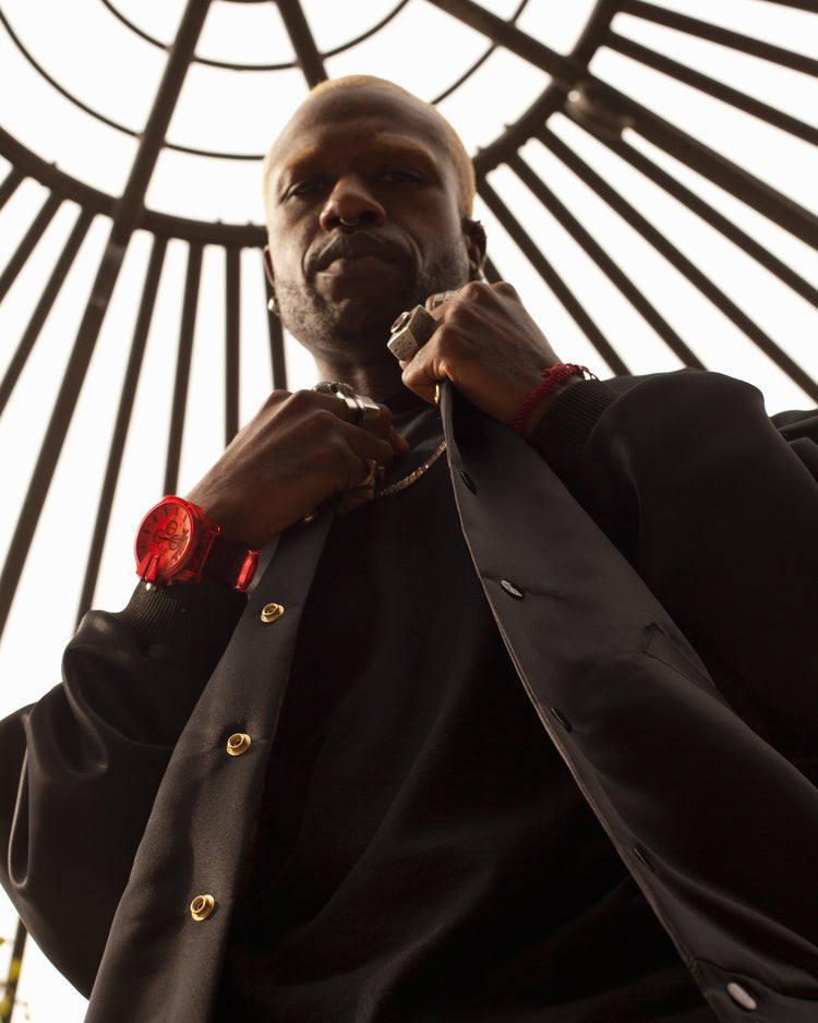 Picture of a male model looking down into the camera wearing the House of Glass Boring Goth Bomber Jacket