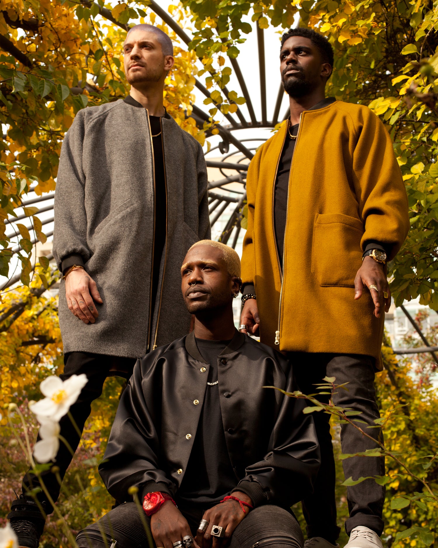 Picture of three male models wearing different House of Glass jackets amidst fall leaves