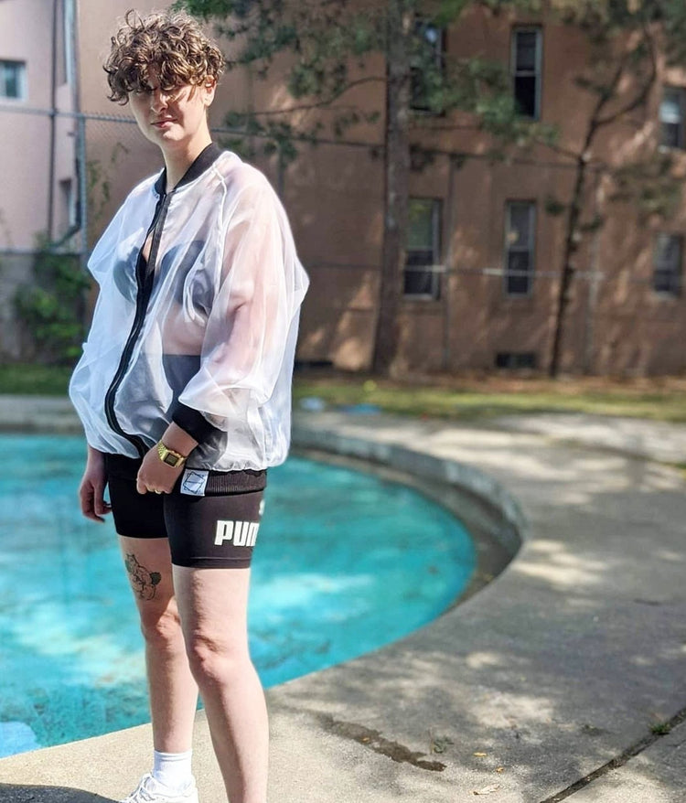 picture of non binary model by a pool wearing Sick White Organza Bomber Jacket