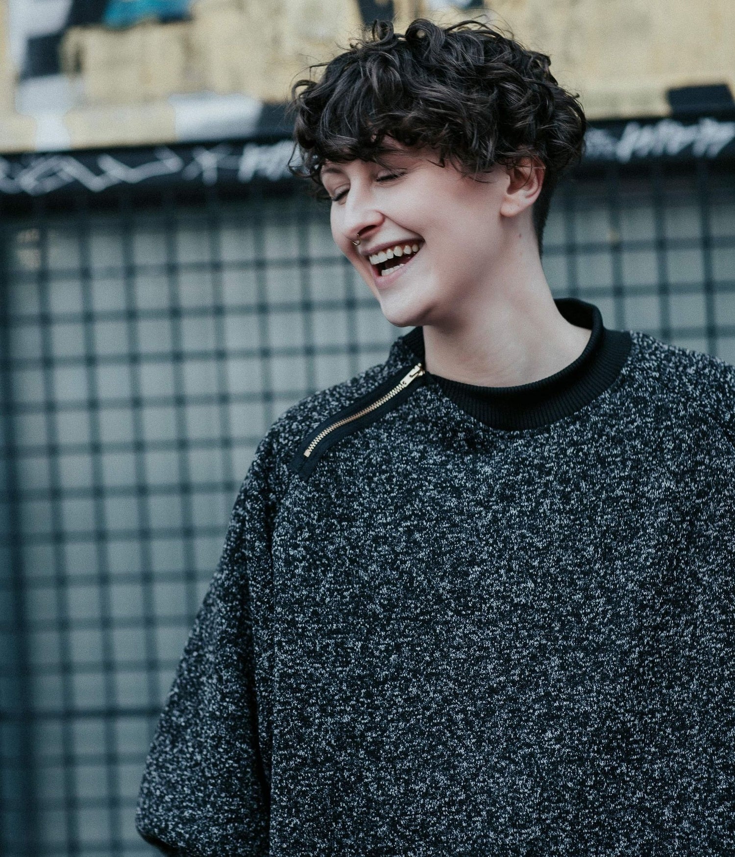 picture of non binary model laughing while wearing house of glass heathered cozy comfy sweater