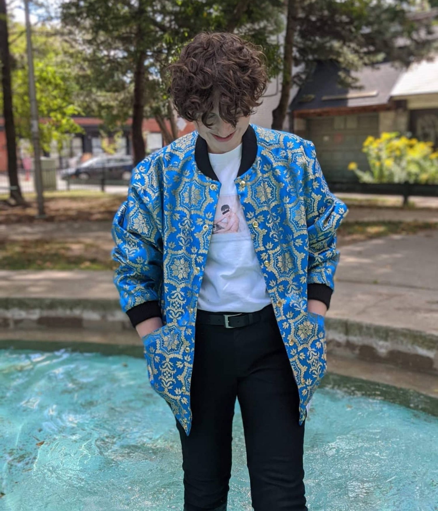 picture of non binary model standing in a swimming pool wearing the St Dimitar Bomber jacket