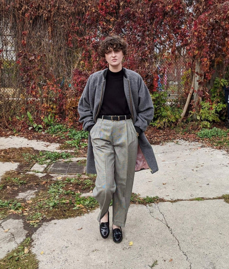 picture of non binary model wearing grey luxe winter coat walking towards the camera