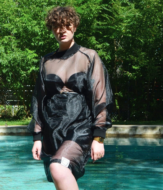 picture of non binary model wearing house of glass long black organza jumper stepping out of swimming pool