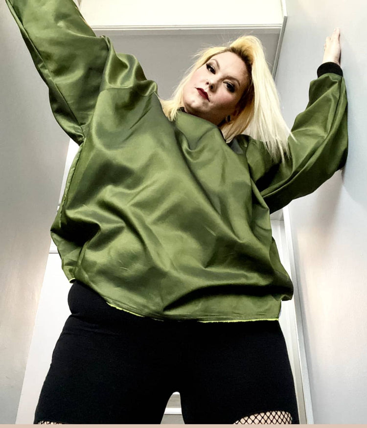 picture of plus size model wearing house of glass olive myself sweater looking down at camera