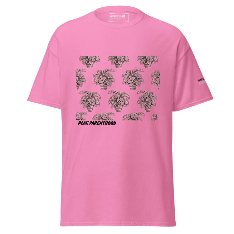 Ghost style front facing T-shirt mockup of a pink short sleeve t-shirt from the House of Glass Pride Collection. The design features a recurring pattern of a black and white potted monstera on the centre front.